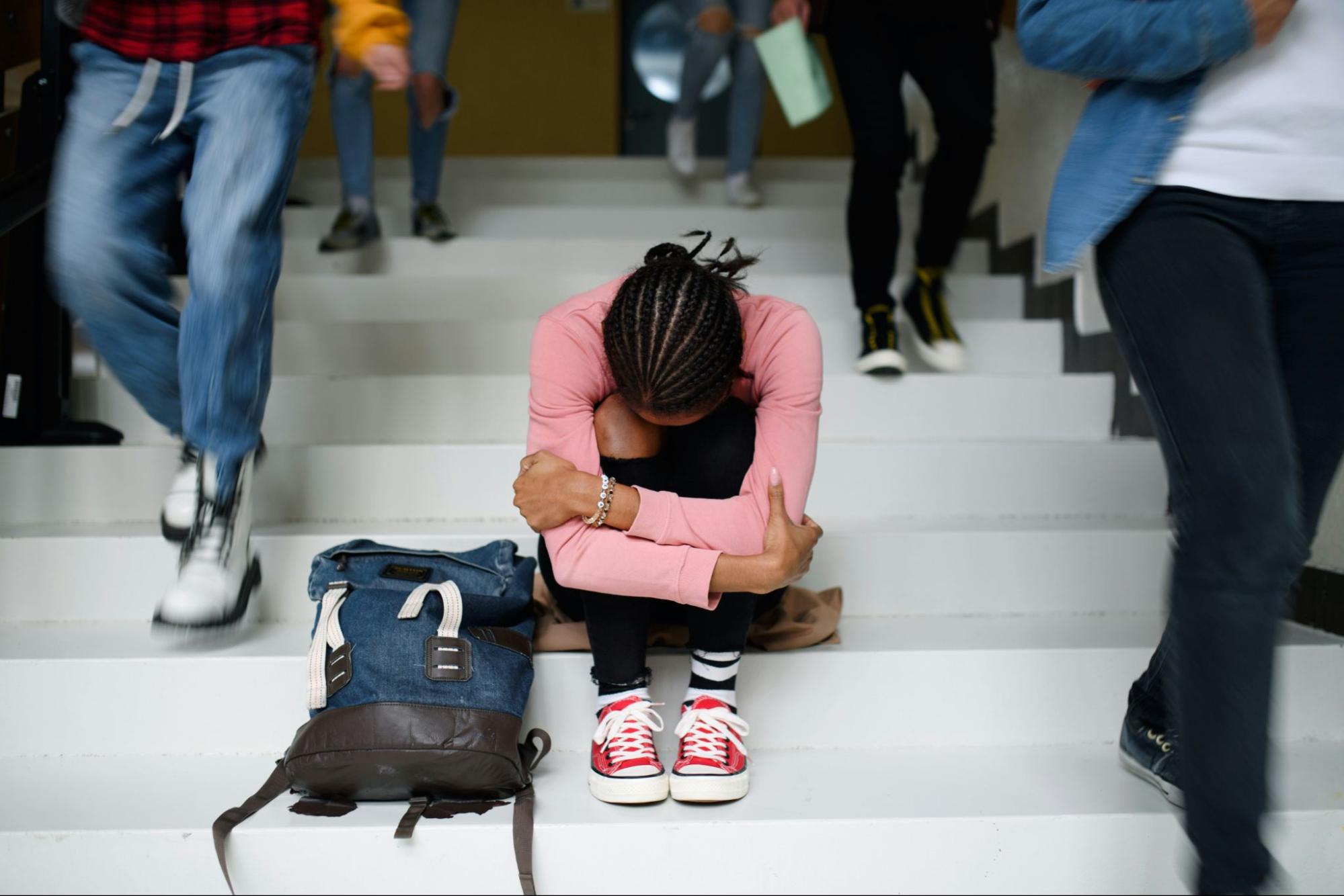 A girl experiencing a breakdown at school, emphasizing the need for understanding complex PTSD triggers and the significance of processing trauma with the help of a trauma specialist.